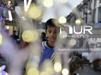 A boy sells fancy lights at a market ahead of the Christmas celebrations in Mumbai, India, on December 13, 2024. (