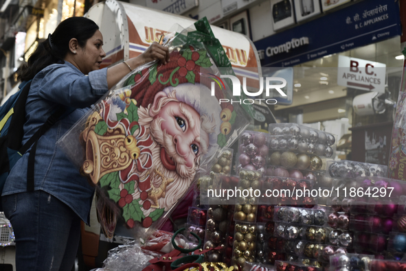 A customer browses Santa Claus stickers ahead of the Christmas celebrations in Mumbai, India, on December 13, 2024. 