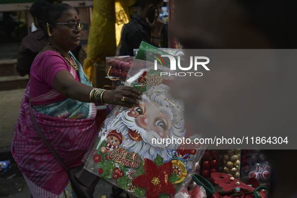 A woman sells Santa Claus stickers at a market ahead of the Christmas celebrations in Mumbai, India, on December 13, 2024. 