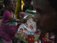 A woman sells Santa Claus stickers at a market ahead of the Christmas celebrations in Mumbai, India, on December 13, 2024. (