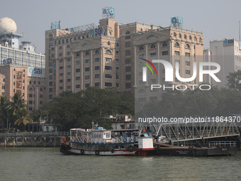 Passengers wait for a ferry on a jetty into the Ganges River while the State Bank of India (SBI) regional office building is pictured in Kol...