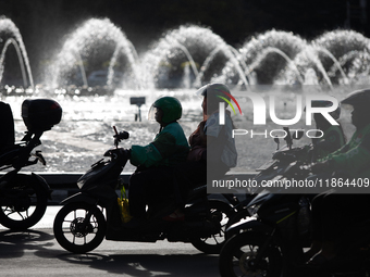 A rider crosses the road during clear weather in Jakarta, Indonesia, on December 12, 2024. The Regional Disaster Management Agency (BPBD) of...