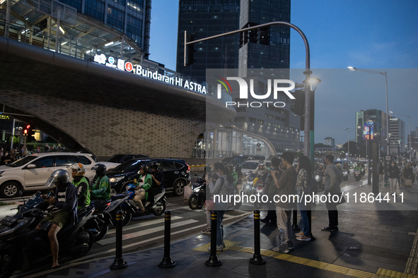 People walk in the business district of Jakarta, Indonesia, on December 12, 2024, during clear weather as evening approaches. The Regional D...