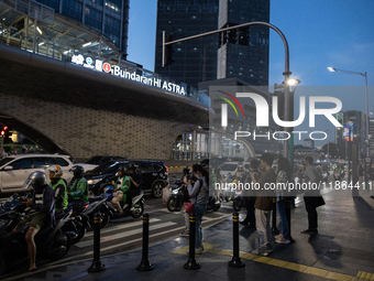 People walk in the business district of Jakarta, Indonesia, on December 12, 2024, during clear weather as evening approaches. The Regional D...