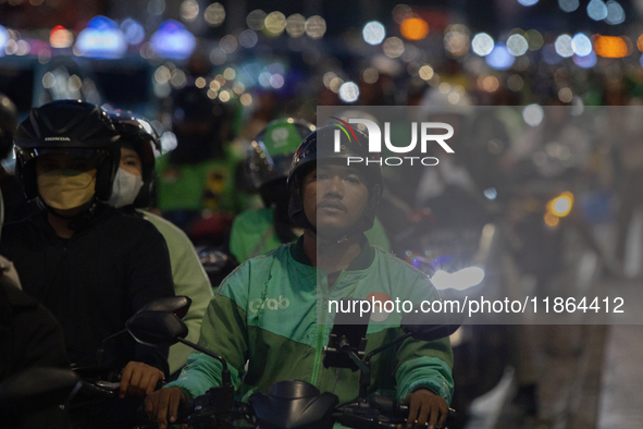 A motorcycle taxi rider is caught in traffic congestion on a street in Jakarta, Indonesia, on December 13, 2024. 