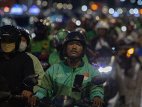 A motorcycle taxi rider is caught in traffic congestion on a street in Jakarta, Indonesia, on December 13, 2024. (