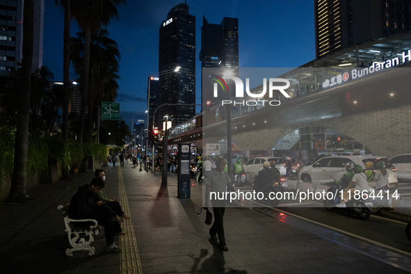 People walk in the business district of Jakarta, Indonesia, on December 12, 2024, during clear weather as evening approaches. The Regional D...