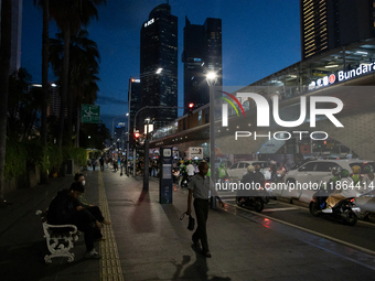 People walk in the business district of Jakarta, Indonesia, on December 12, 2024, during clear weather as evening approaches. The Regional D...