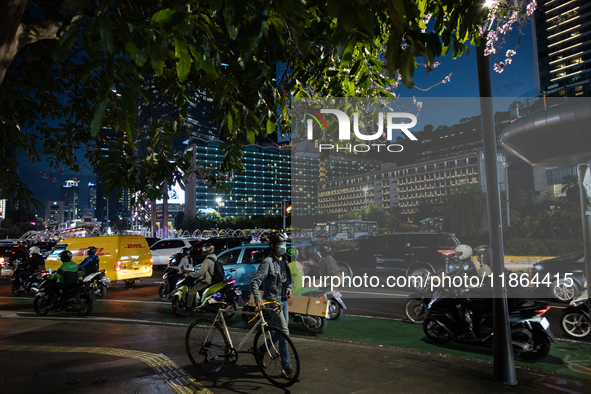 People walk in the business district of Jakarta, Indonesia, on December 12, 2024, during clear weather as evening approaches. The Regional D...