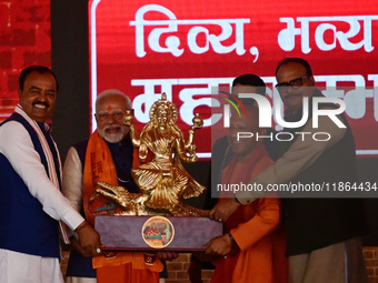 Uttar Pradesh Chief Minister Yogi Adityanath presents a statue of Ganga during the inauguration of various development projects for the '202...