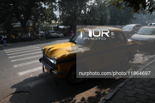 A taxi driver waits for passengers with his iconic yellow Ambassador taxi in Kolkata, India, on December 13, 2024. The Calcutta High Court o...