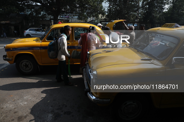 Passengers ride in an iconic yellow Ambassador taxi in Kolkata, India, on December 13, 2024. The Calcutta High Court orders that Kolkata's i...