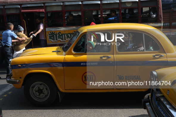 Passengers travel in an iconic yellow Ambassador taxi in Kolkata, India, on December 13, 2024. The Calcutta High Court orders that Kolkata's...