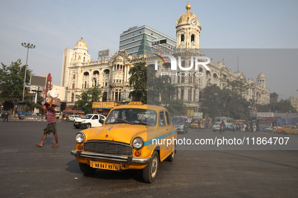 An iconic yellow Ambassador taxi crosses the road junctions in Kolkata, India, on December 13, 2024. The Calcutta High Court orders that Kol...