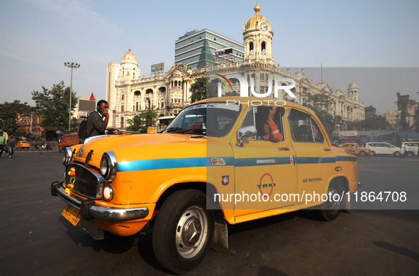 An iconic yellow Ambassador taxi crosses the road junctions in Kolkata, India, on December 13, 2024. The Calcutta High Court orders that Kol...