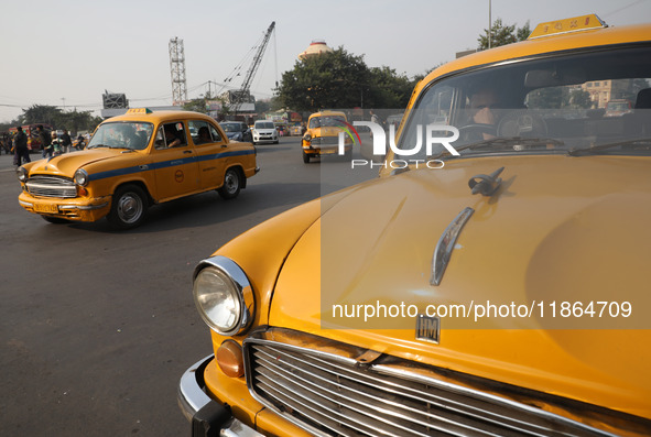 An iconic yellow Ambassador taxi crosses the road junctions in Kolkata, India, on December 13, 2024. The Calcutta High Court orders that Kol...