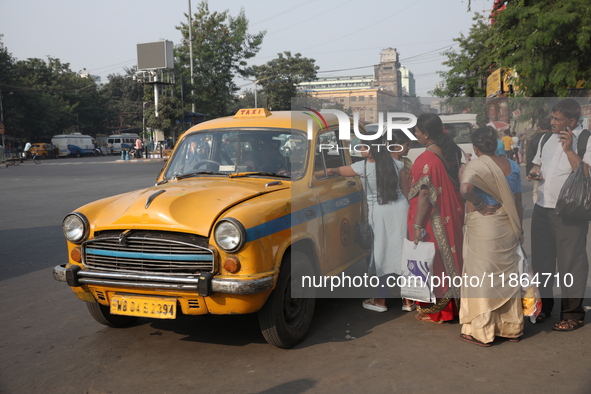 Passengers ride in an iconic yellow Ambassador taxi in Kolkata, India, on December 13, 2024. The Calcutta High Court's 2008 order states tha...