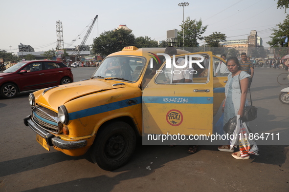 Passengers ride in an iconic yellow Ambassador taxi in Kolkata, India, on December 13, 2024. The Calcutta High Court orders that Kolkata's i...