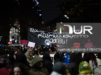 Anti-government protesters demonstrate against the Georgian government's postponement of European Union accession talks until 2028, in Tbili...