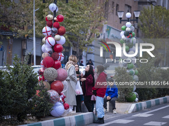 Iranian women stand together next to Christmas decorations put up by the municipality of District Six while Christmas shopping in downtown T...