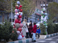 Iranian women stand together next to Christmas decorations put up by the municipality of District Six while Christmas shopping in downtown T...