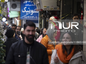 A young Iranian woman smiles as she looks at a statue of Santa Claus while Christmas shopping in downtown Tehran, Iran, on December 13, 2024...