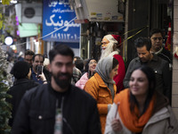 A young Iranian woman smiles as she looks at a statue of Santa Claus while Christmas shopping in downtown Tehran, Iran, on December 13, 2024...