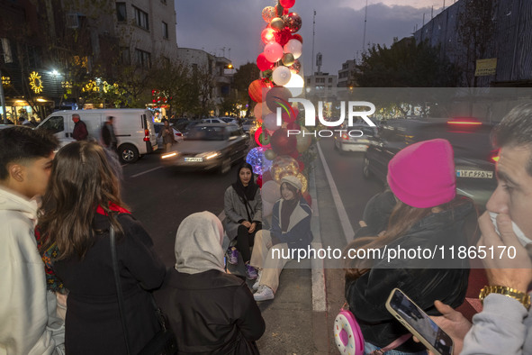 Two young Iranian women pose for a photograph with Christmas decorations put up by the municipality of District Six while Christmas shopping...