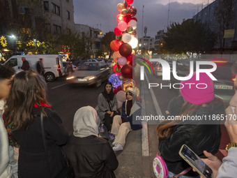 Two young Iranian women pose for a photograph with Christmas decorations put up by the municipality of District Six while Christmas shopping...