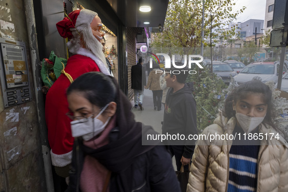 Young Iranian women walk past a statue of Santa Claus while Christmas shopping in downtown Tehran, Iran, on December 13, 2024. Iranian-Chris...