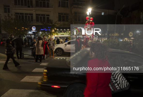 Young Iranian women pose for a photograph with Christmas decorations put up by the municipality of District Six while Christmas shopping in...