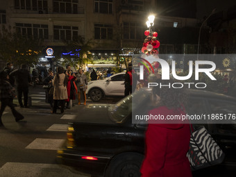 Young Iranian women pose for a photograph with Christmas decorations put up by the municipality of District Six while Christmas shopping in...