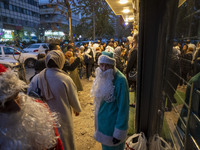 An Iranian-Christian man dressed as Santa Claus stands on a sidewalk during Christmas shopping in downtown Tehran, Iran, on December 13, 202...