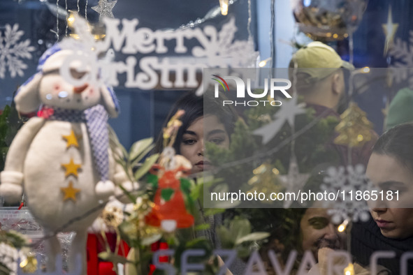 A young Iranian woman stands at a cafe decorated for Christmas during Christmas shopping in downtown Tehran, Iran, on December 13, 2024. Ira...