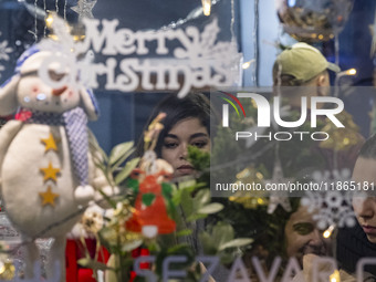 A young Iranian woman stands at a cafe decorated for Christmas during Christmas shopping in downtown Tehran, Iran, on December 13, 2024. Ira...