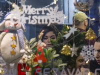 A young Iranian woman stands at a cafe decorated for Christmas during Christmas shopping in downtown Tehran, Iran, on December 13, 2024. Ira...