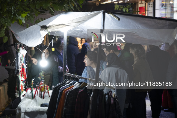 A young Iranian woman shops for Christmas accessories from a vendor in downtown Tehran, Iran, on December 13, 2024. Iranian-Christians celeb...