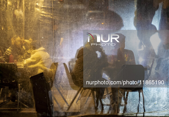 Iranian people sit at an outdoor cafe during Christmas shopping in downtown Tehran, Iran, on December 13, 2024. While Iranian-Christians cel...