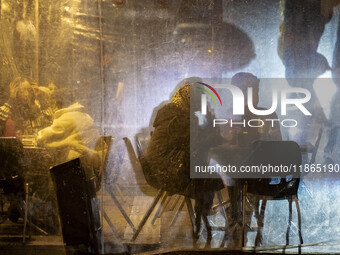 Iranian people sit at an outdoor cafe during Christmas shopping in downtown Tehran, Iran, on December 13, 2024. While Iranian-Christians cel...