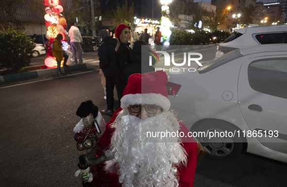 An Iranian-Christian man dressed as Santa Claus sits on a street-side during Christmas shopping in downtown Tehran, Iran, on December 13, 20...