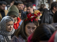 A young Iranian woman wears a Christmas accessory as she walks along a sidewalk while Christmas shopping in downtown Tehran, Iran, on Decemb...