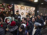 Iranian-Christian people stand in line while waiting to enter a shop decorated for Christmas shopping in downtown Tehran, Iran, on December...