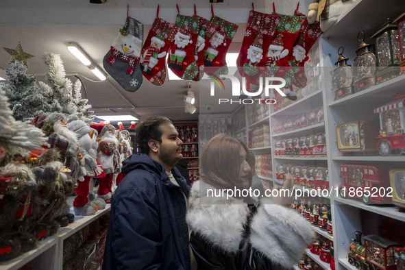 An Iranian-Christian couple looks at Christmas accessories while shopping for Christmas at a shop in downtown Tehran, Iran, on December 13,...