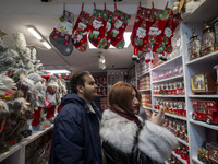 An Iranian-Christian couple looks at Christmas accessories while shopping for Christmas at a shop in downtown Tehran, Iran, on December 13,...