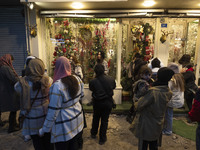 Young Iranian women stand on a sidewalk outside a shop decorated for Christmas shopping in downtown Tehran, Iran, on December 13, 2024. Whil...