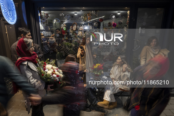 Young Iranian women are outside a cafe during Christmas shopping in downtown Tehran, Iran, on December 13, 2024. While Iranian-Christians ce...