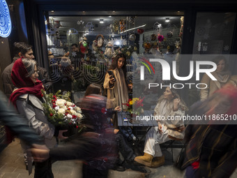 Young Iranian women are outside a cafe during Christmas shopping in downtown Tehran, Iran, on December 13, 2024. While Iranian-Christians ce...