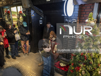 An Iranian street musician plays the accordion on a sidewalk during Christmas shopping in downtown Tehran, Iran, on December 13, 2024. Irani...