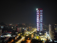 A large LED screen on the exterior wall of a building displays a propaganda slogan to commemorate the innocent victims of the Nanjing Massac...