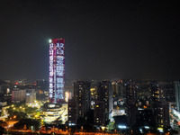 A large LED screen on the exterior wall of a building displays a propaganda slogan to commemorate the innocent victims of the Nanjing Massac...